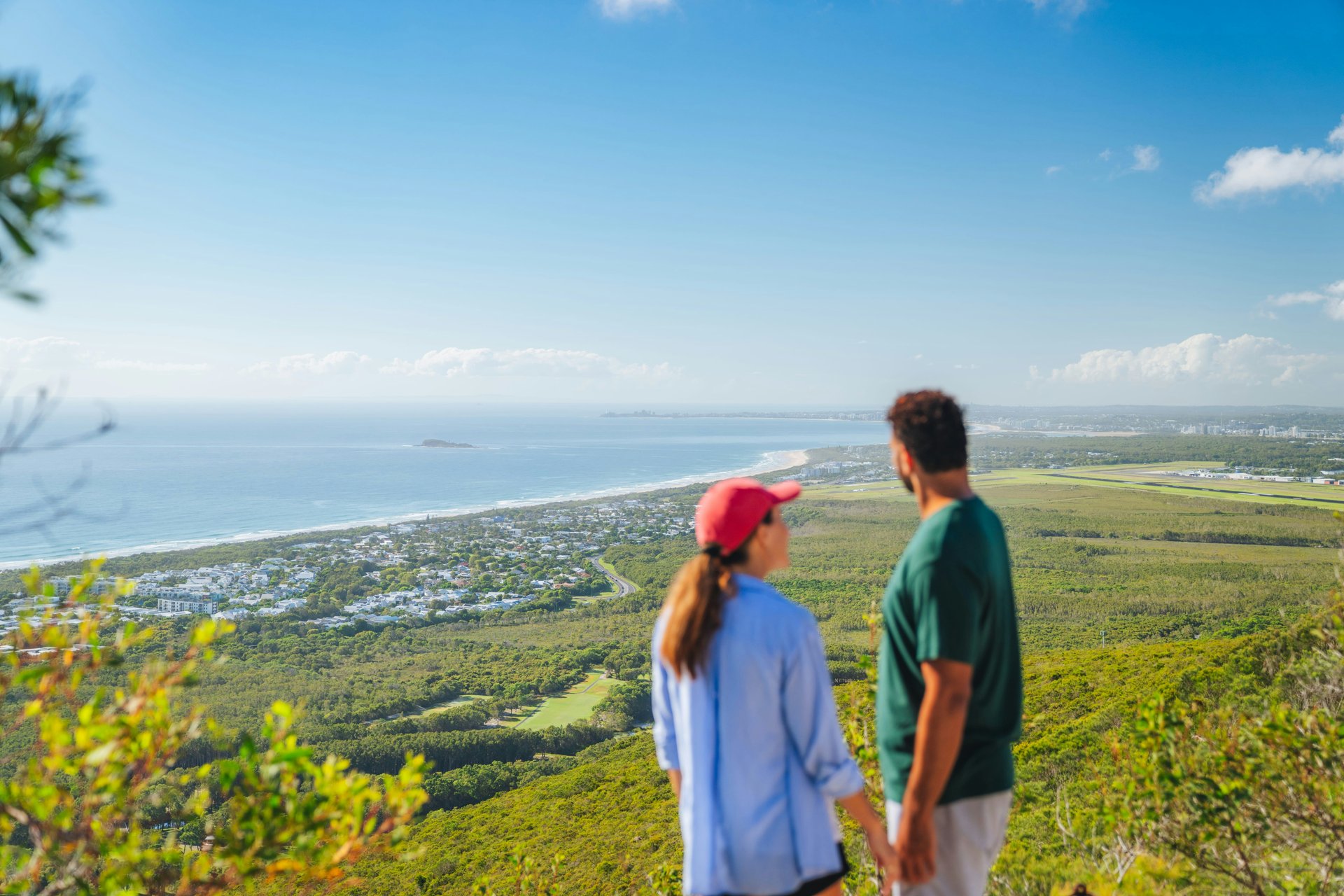 Travellers looking across green countryside towards the coast