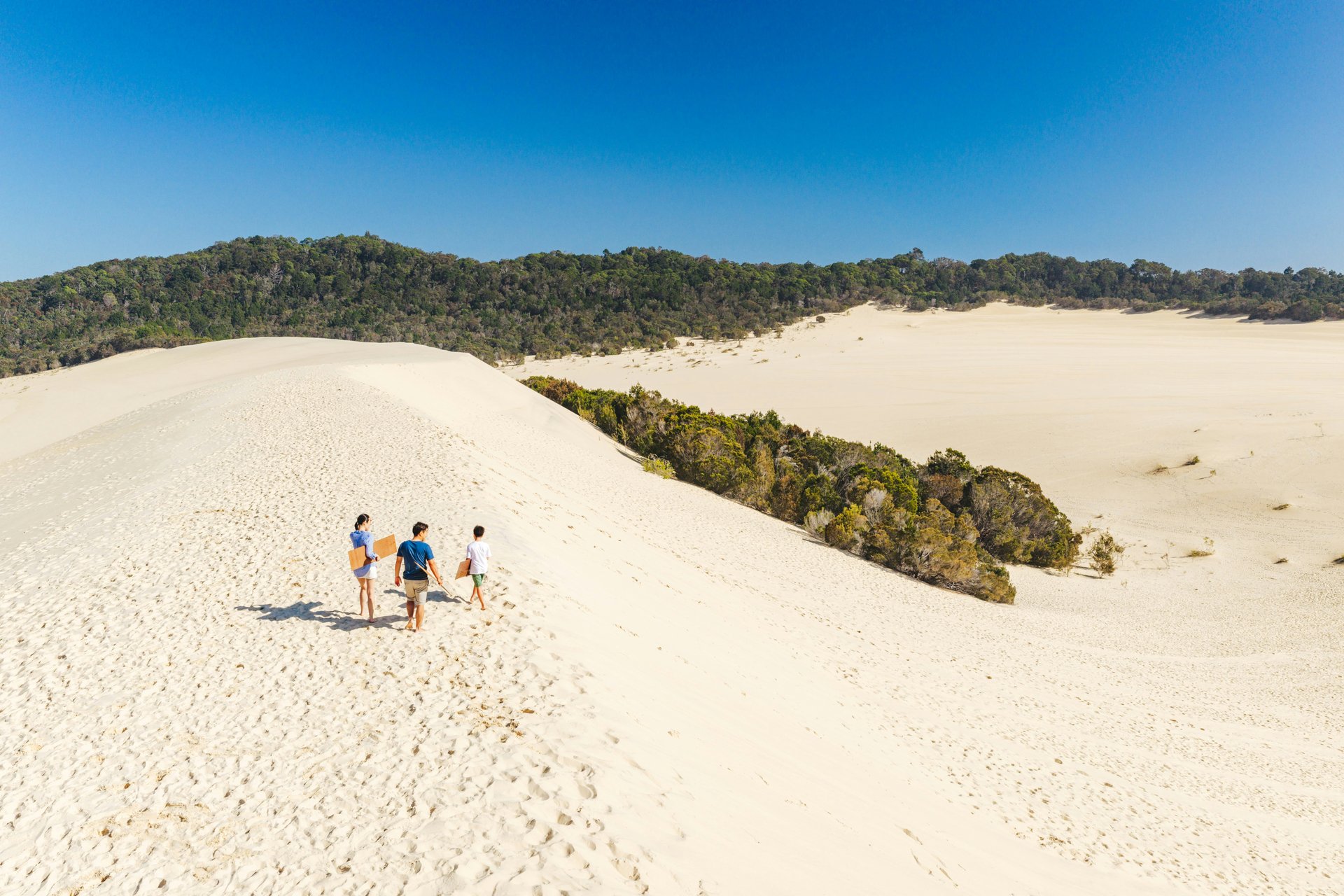 Friends exploring broad Queensland sand dunes