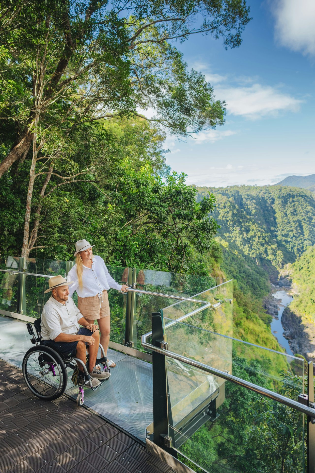 Travellers taking in a green valley from a forest lookout