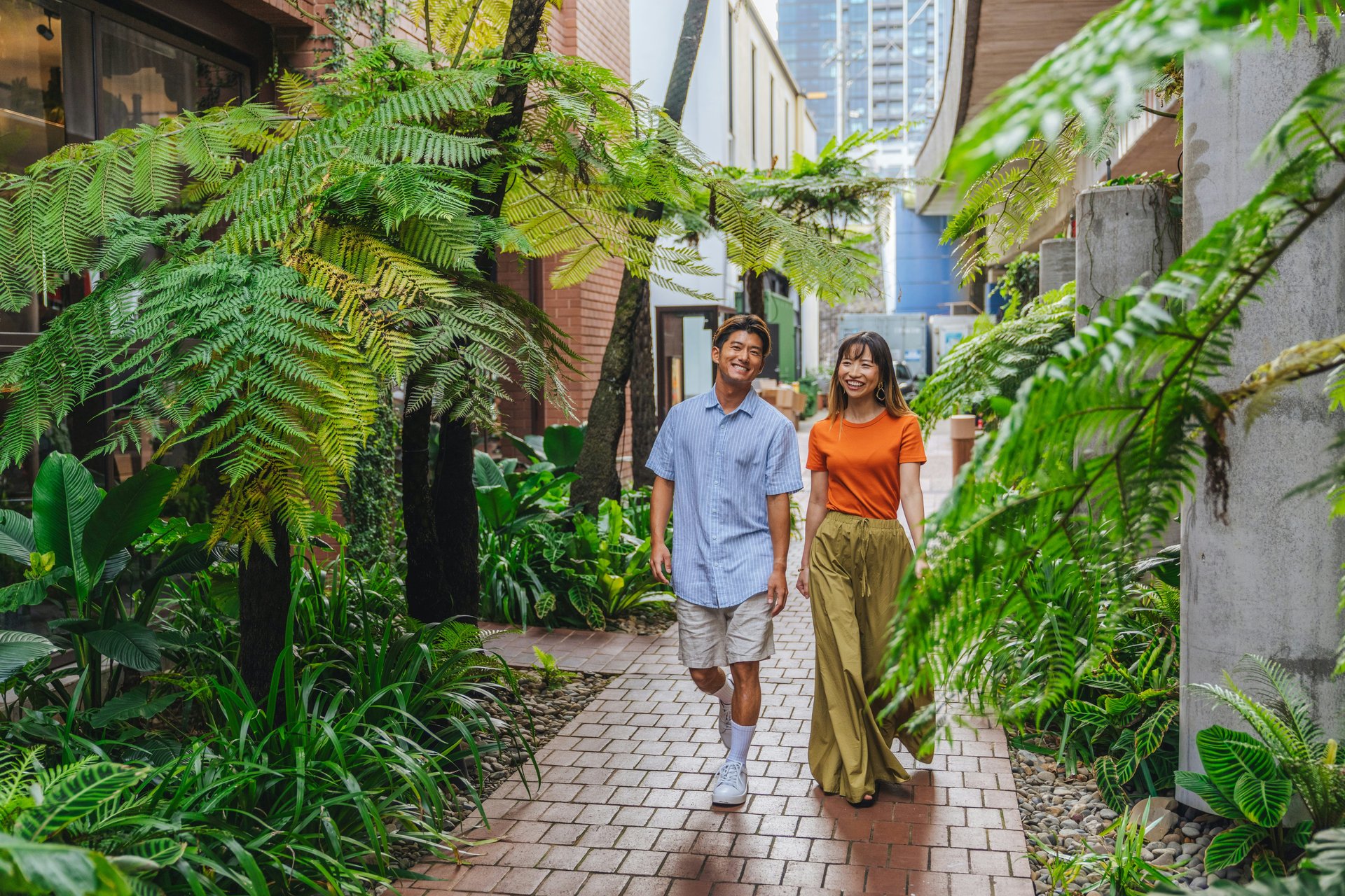 A couple walking through a leafy outdoor passage